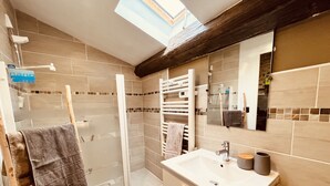 A modern bathroom with a glass shower enclosure, a vanity with a sink and mirror, and a towel rack. - Le Cocon Charmant Studio (Nîmes)