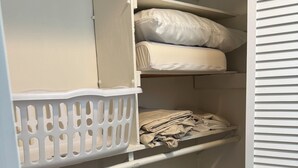 A closet with shelves, a hanging rack, and a plastic basket. -  1 bdrm condo. Indoor parking garage. Secure bldg access.  90 day minimum stay (Anchorage)