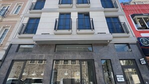 A multi-story hotel with a modern facade, large windows, and a dining area with outdoor seating. - Iris Han Hotel (Istanbul)