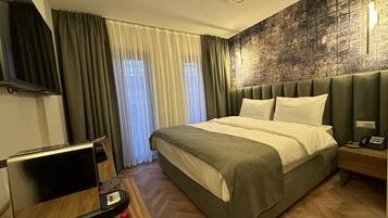 Deluxe tweepersoonskamer | Luxe beddengoed, een minibar, een bureau, een laptopwerkplek