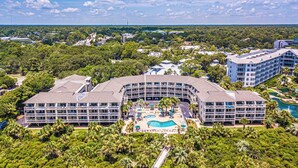 A resort with a central pool, multiple buildings, and surrounding greenery. - 321 Oceanfront Villa | Walk to Coligny + Pools | Washer/Dryer (Hilton Head Island)