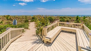 A wooden boardwalk leading to a beach with a bench and a sign indicating no swimming. - 321 Oceanfront Villa | Walk to Coligny + Pools | Washer/Dryer (Hilton Head Island)