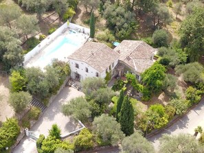 Vue aérienne d’une propriété dotée d’une piscine, de toits en terrasses et d’une végétation luxuriante.