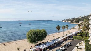 Un mercado en la playa con carpas y coches estacionados a lo largo de la orilla.