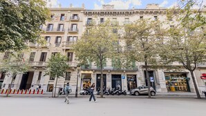 Un edificio histórico con varios pisos, balcones y una entrada a nivel de calle.