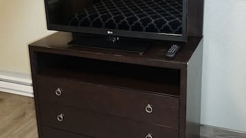 Ein dunkles Holz-TV-Möbel mit Fernseher und Fernbedienung.