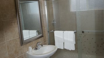 A bathroom with a toilet, sink, and shower.