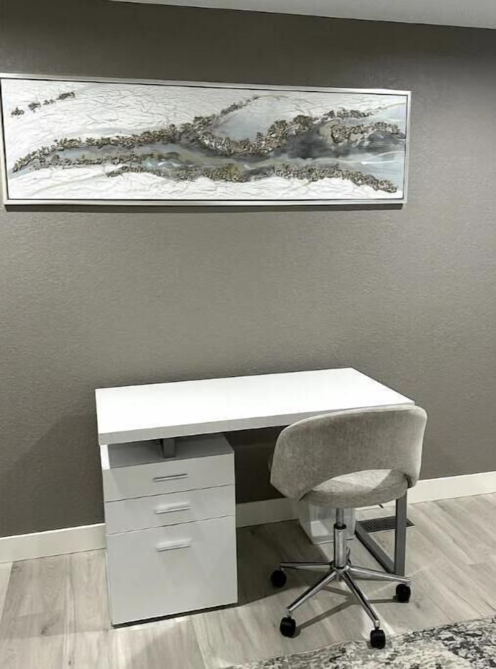 Ein Zimmer mit weißem Schreibtisch, grauer Wand und einem Landschaftsbild darüber.