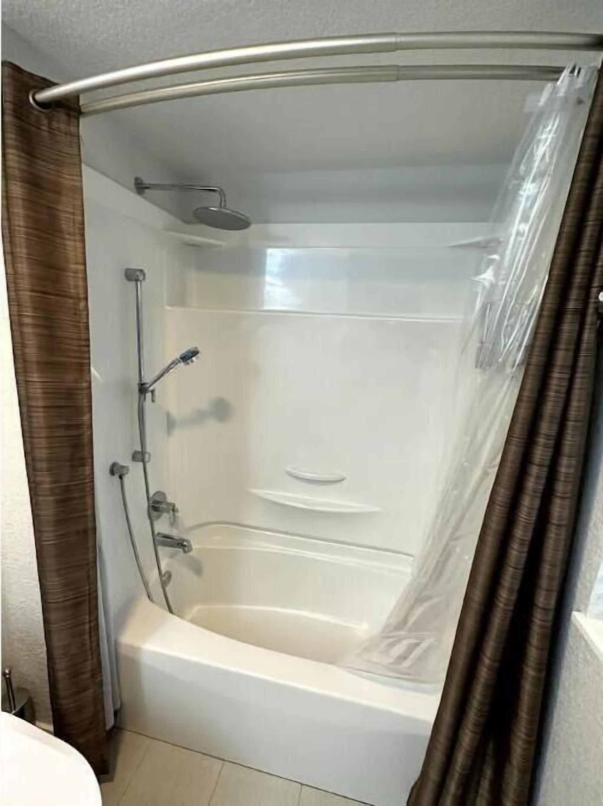 Une salle de bain moderne avec une douche à parois de verre, une baignoire et des toilettes.