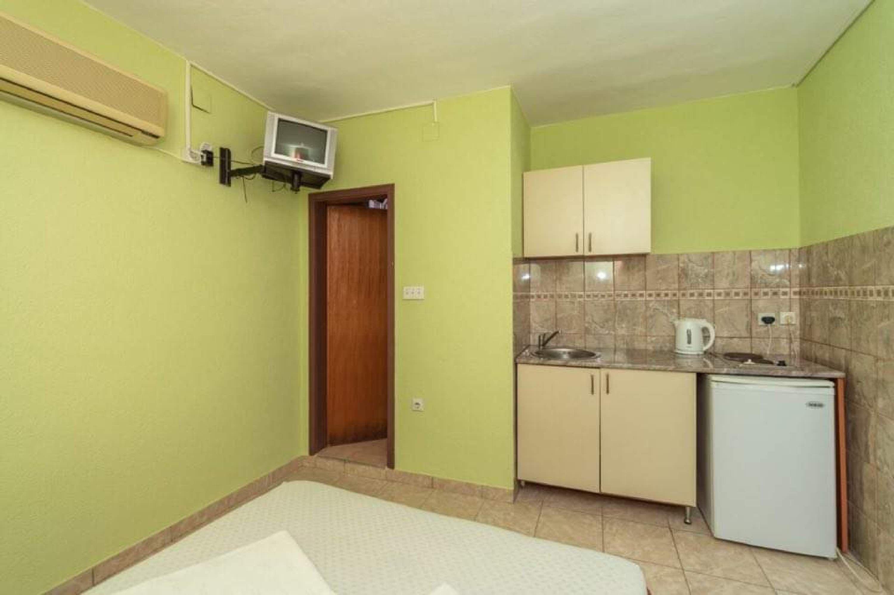 A compact kitchen with a microwave, a small refrigerator, and a sink.