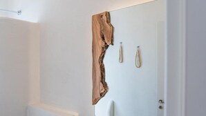 Un baño con un espejo grande, toallero y cortina de ducha.