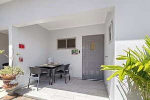 Ein kleiner Innenhof mit Tisch, Stühlen, einem Blumentopf und einer Tür.