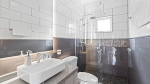 Un baño moderno con una bañera grande, zona de ducha separada y un inodoro.
