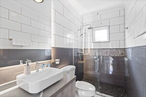 Un bagno moderno con una vasca da bagno ampia, una cabina doccia separata e un WC.