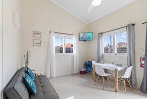 Lavish living and dinning area of the apartment in Noord, Aruba - Cosy sofas - Beautifully located windows of the apartment with outside views - 3 Persons dinning - Beautifully decored with wall paintings - Availability of TV and Netflix
