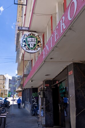 A hotel entrance with a sign reading 'HOTEL LOURDES 62' and a '24 HORAS' sign above it. - Hotel Lourdes 62 (Bogotá)