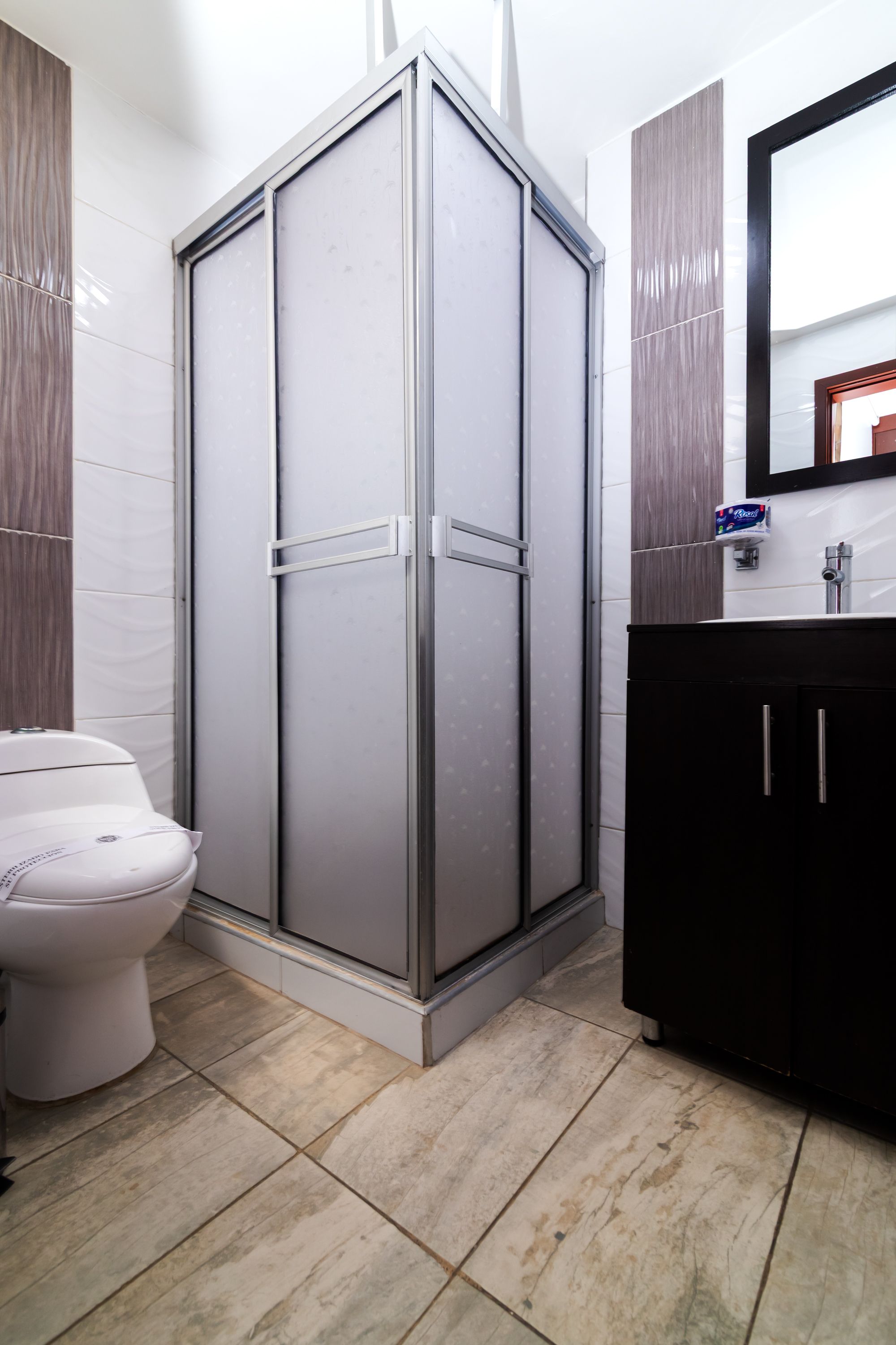Ein Badezimmer mit Toilette, Duschkabine und Waschbecken.