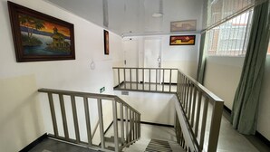 A staircase with a metal railing, a painting on the wall, and a door at the top. - Hotel Lourdes 62 (Bogotá)