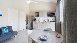 A modern kitchen with white cabinets, a microwave, and a refrigerator. - Aruba 1BR Apartment w Free Parking near Palm Beach (Noord)