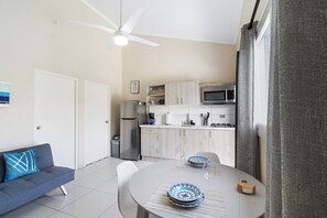 A modern kitchen with white cabinets, a microwave, and a refrigerator. - Aruba 1BR Apartment w Free Parking near Palm Beach (Noord)