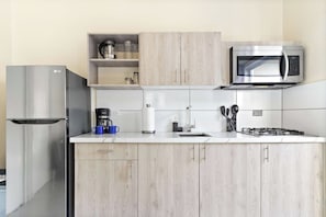 Eine moderne Küche mit Edelstahlgeräten, Holzschränken und einer weißen Arbeitsplatte.