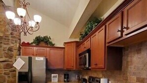 A kitchen with wooden cabinets, a stainless steel refrigerator, a microwave, and a sink. - Lake Views from this Balcony are amazing! (Hot Springs)