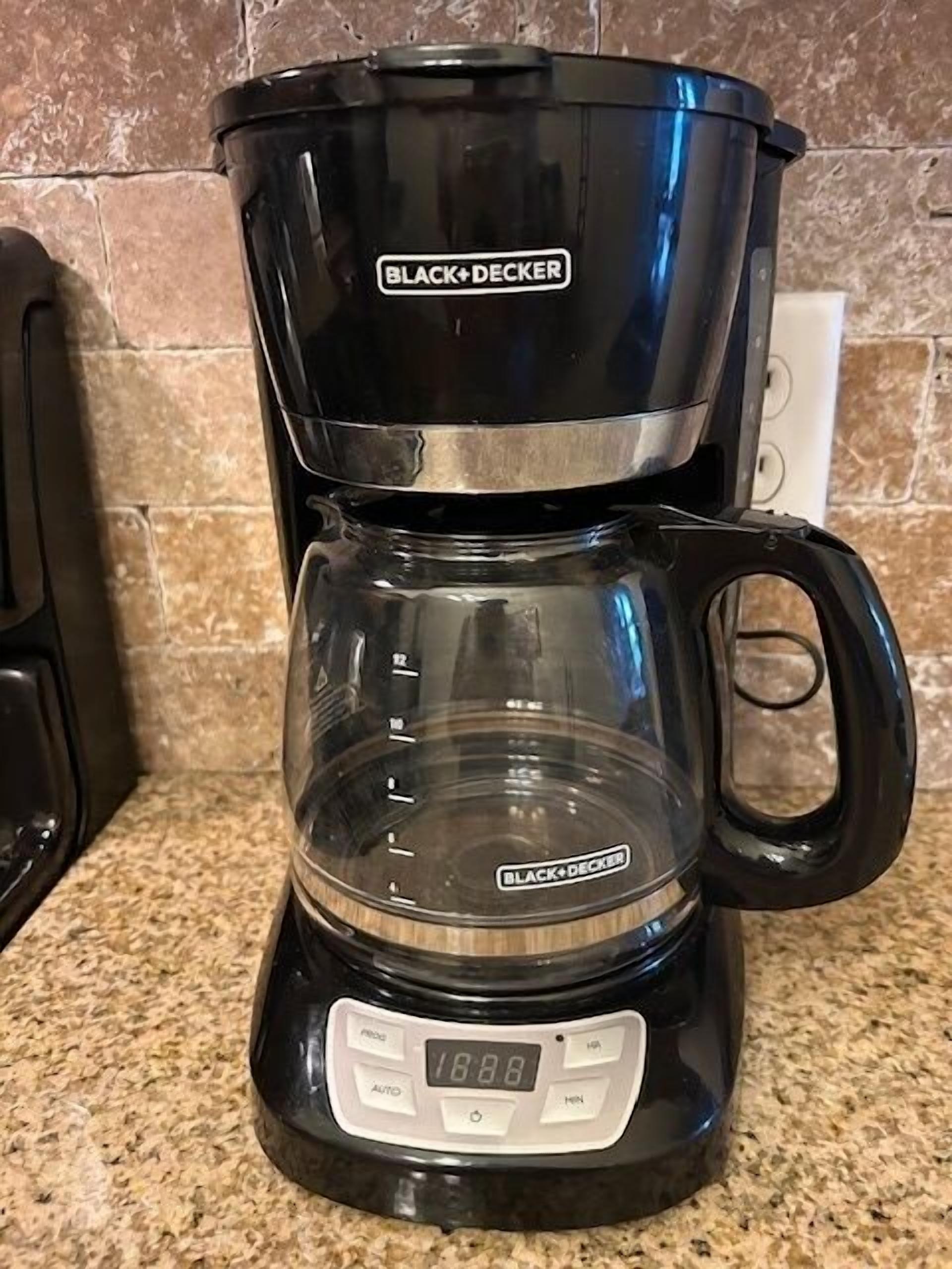 Una macchina da caffè BLACK+DECKER con display digitale su un piano di lavoro della cucina.