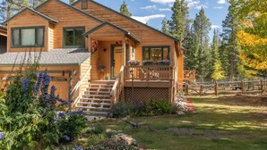 A wooden cabin with a porch, steps, and a fenced yard. - Peak 7, dog friendly fenced in yard, hot tub, pool table & dedicated work space (Breckenridge)
