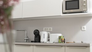 Une cuisine moderne équipée d’un four à micro-ondes Bosch, d’une machine à café et d’une bouilloire.