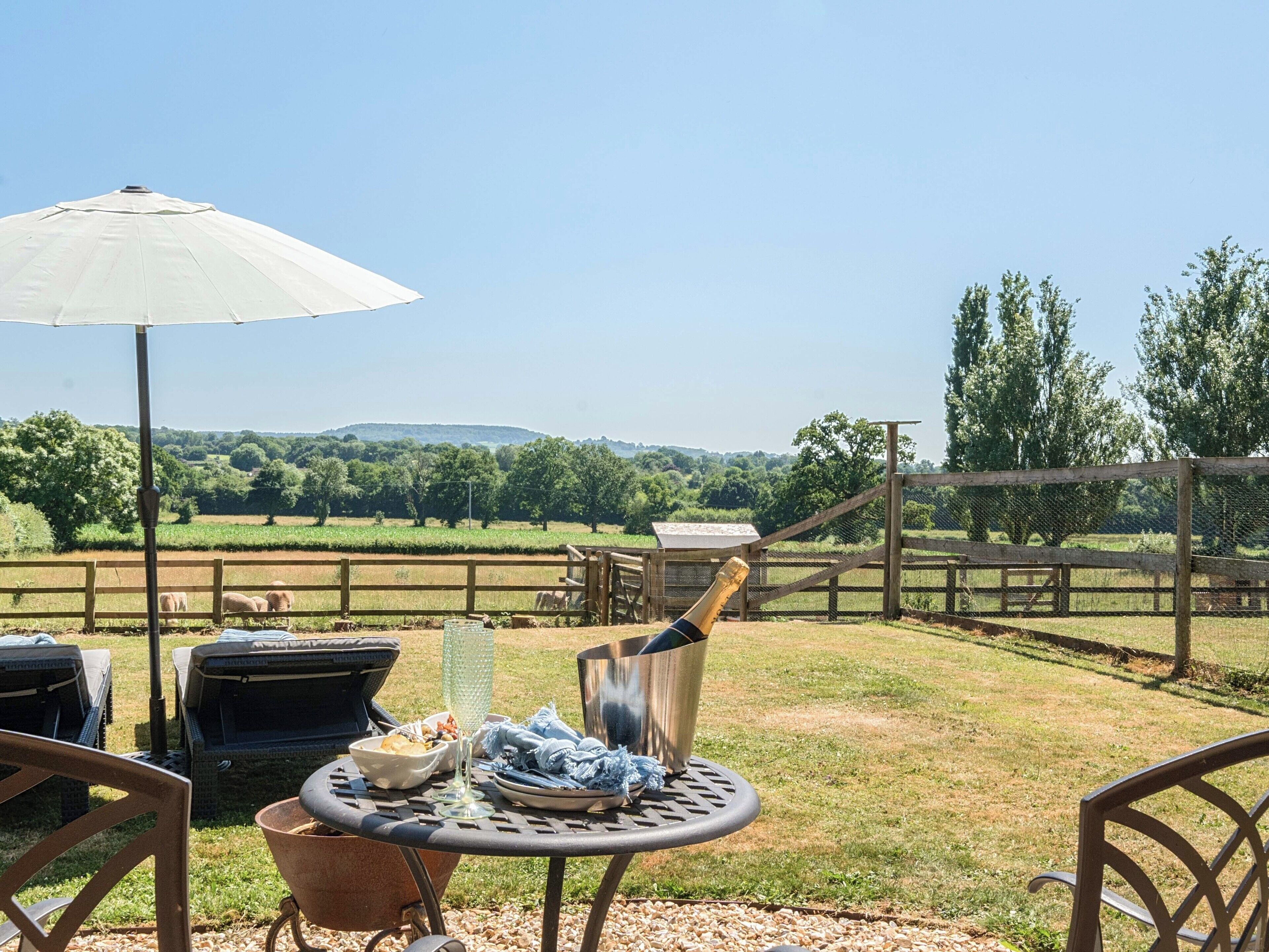 An outdoor patio with a table, chairs, and a grill.