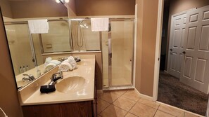Un bagno con lavandino, specchio, portasci e doccia.