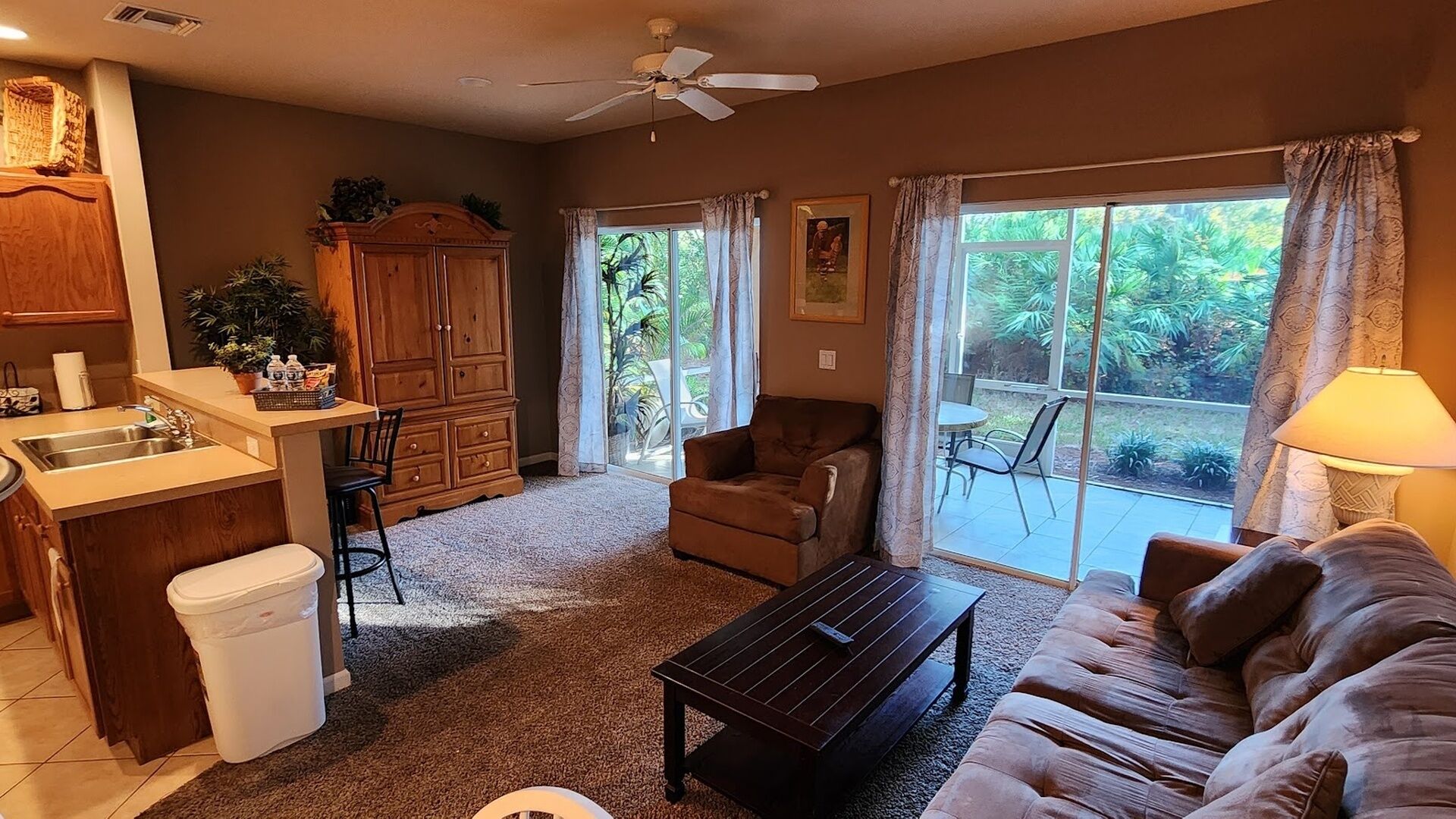 A living room with a sofa, a coffee table, a cabinet, and a window with curtains.