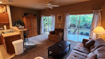 A living room with a sofa, a coffee table, a cabinet, and a window with curtains.