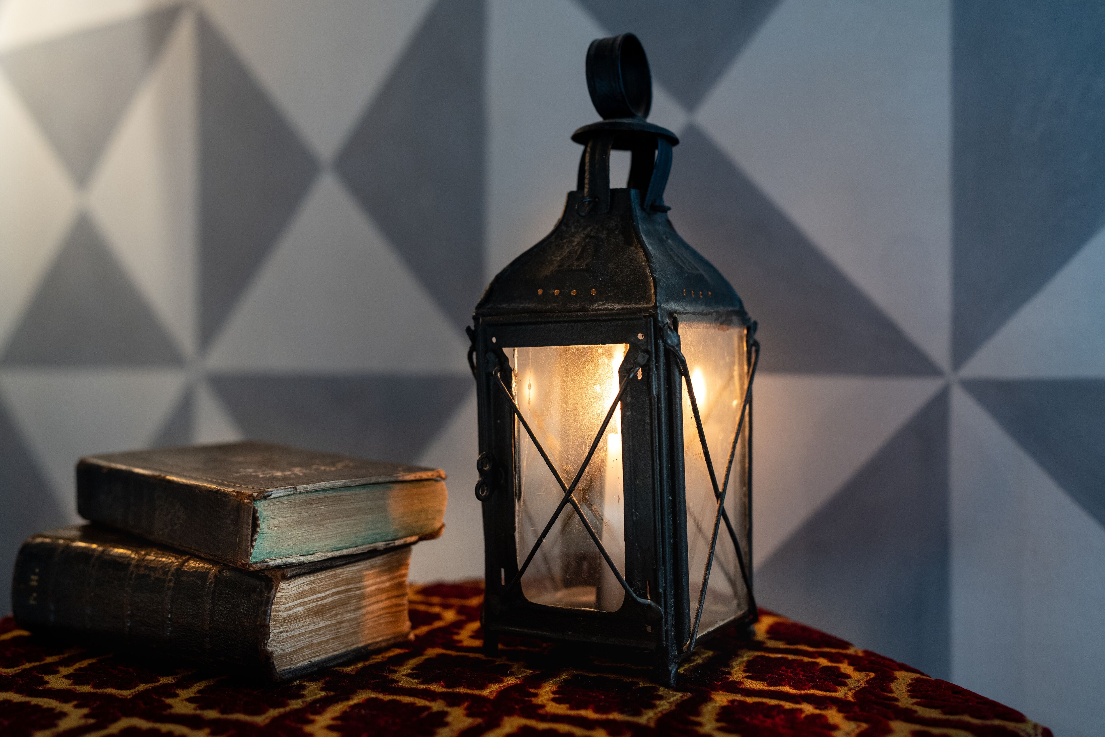 Un farol, dos libros y un mantel estampado.