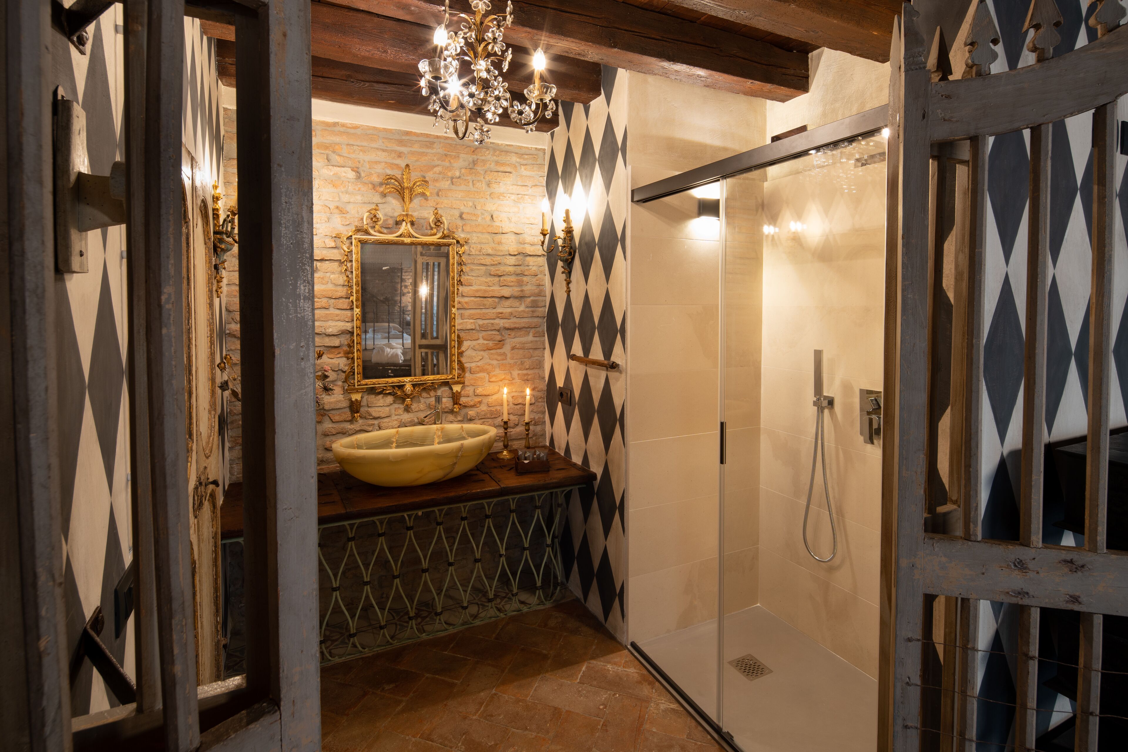 A bathroom with a stone wall, a large mirror, a yellow sink, and a shower area.