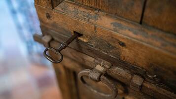 Gros plan d’une porte en bois rustique, dotée d’un loquet en métal et d’un trou de serrure.