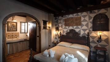 Un dormitorio con una cama grande, cabecera de madera, mesita de noche, lámpara de pared y pared con diseño.