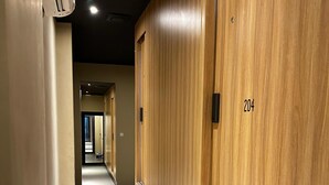 Un pasillo con taquillas de madera, numeradas 204, y suelo alfombrado.