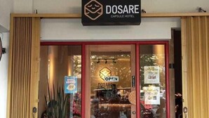 La entrada a un hotel llamado 'DOSARE' con un letrero que indica 'ABIERTO'.