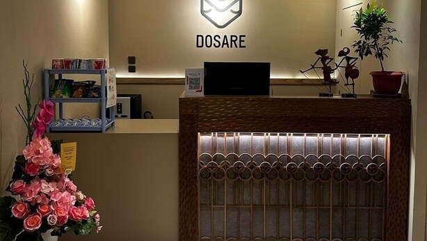 Un área de recepción con un letrero que dice "DOSARE" y un mostrador con respaldo tejido.