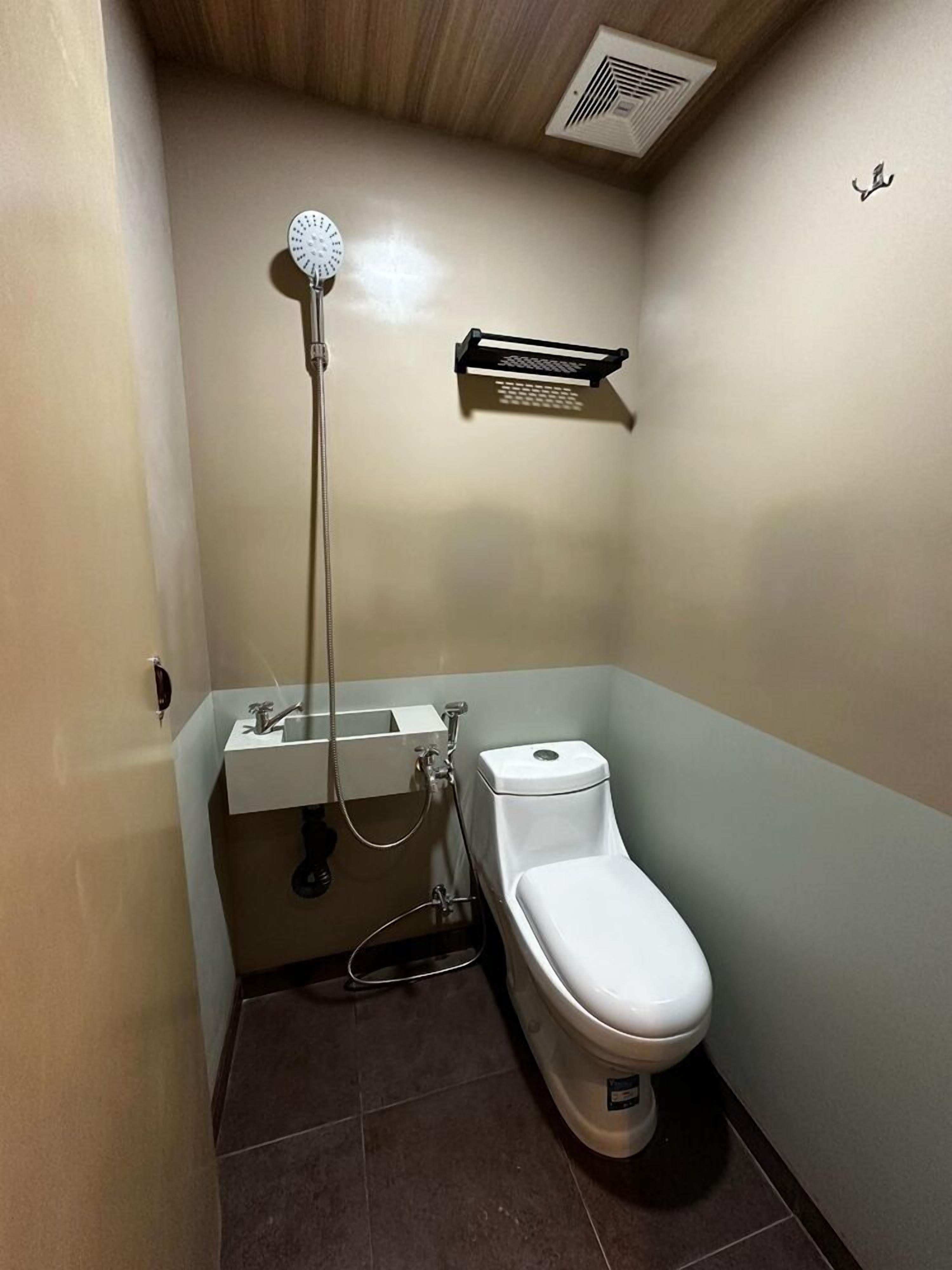 A small bathroom with a toilet, a sink, and a shower.