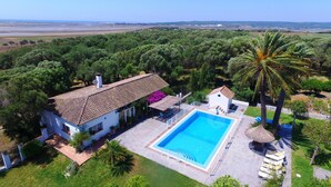 A house with a swimming pool, surrounded by lush greenery and a clear view of the countryside. - Alojamiento Rural Para Grupos DE 20 Personas (BARBATE)