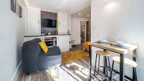 Eine moderne Wohnung mit Wohnbereich, Küche und Essplatz.
