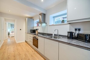 Een koelkast, een kinderstoel, kookgerei, borden en bestek