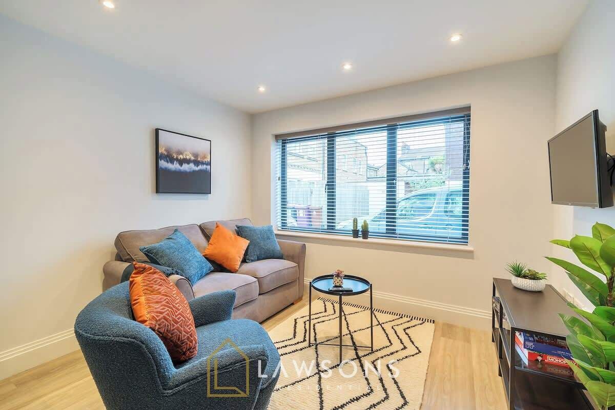 A modern living room with a sofa, a coffee table, and a TV.