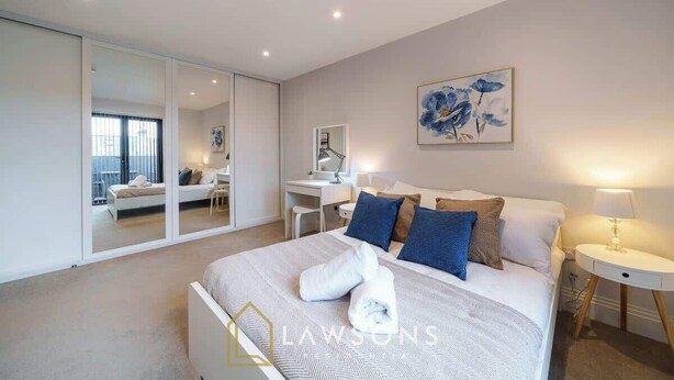 A modern bedroom with a large bed, a desk, and a sliding door leading to a balcony. - Central Windsor Gem | 1BR Penthouse + Balcony (Windsor)