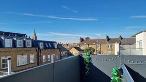 A residential area with terraced houses, a church spire, and a clear blue sky. - Central Windsor Gem | 1BR Penthouse + Balcony (Windsor)
