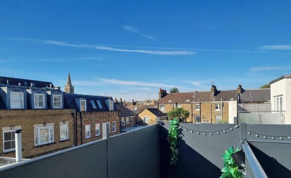 A residential area with terraced houses, a church spire, and a clear blue sky. - Central Windsor Gem | 1BR Penthouse + Balcony (Windsor)