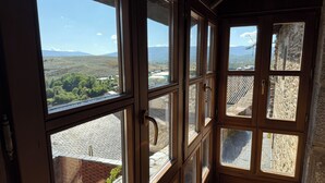 Habitación con amplios ventanales que ofrecen vistas a un paisaje montañoso.