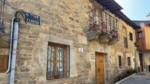 Un edificio de piedra con puerta de madera, una ventana con reja de metal y un cartel que dice "Calle de la Florida".
